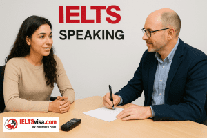 A student and an examiner sit across from each other at a desk during an IELTS Speaking test. The examiner holds a pen and paper, and a voice recorder is placed on the table.